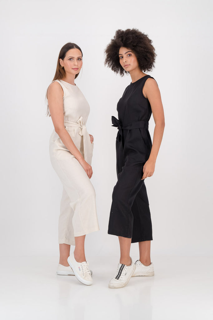 Two women wearing black and oat Clarke Jumpsuits facing sideways