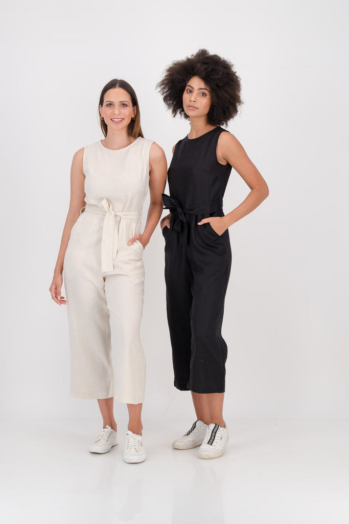 Two women wearing black and white jumpsuits facing forwards