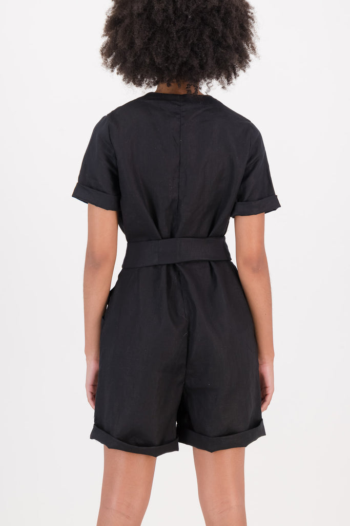 Woman wearing a black Riley Jumpsuit facing backwards