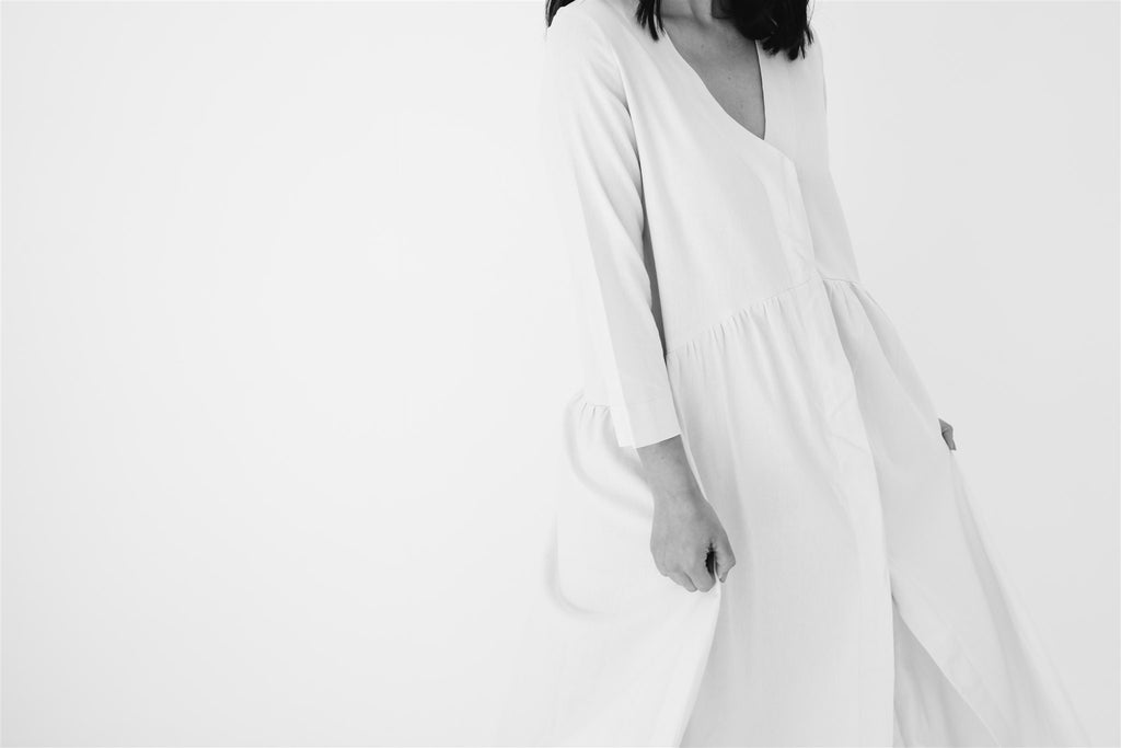 Woman wearing a white dress facing forwards